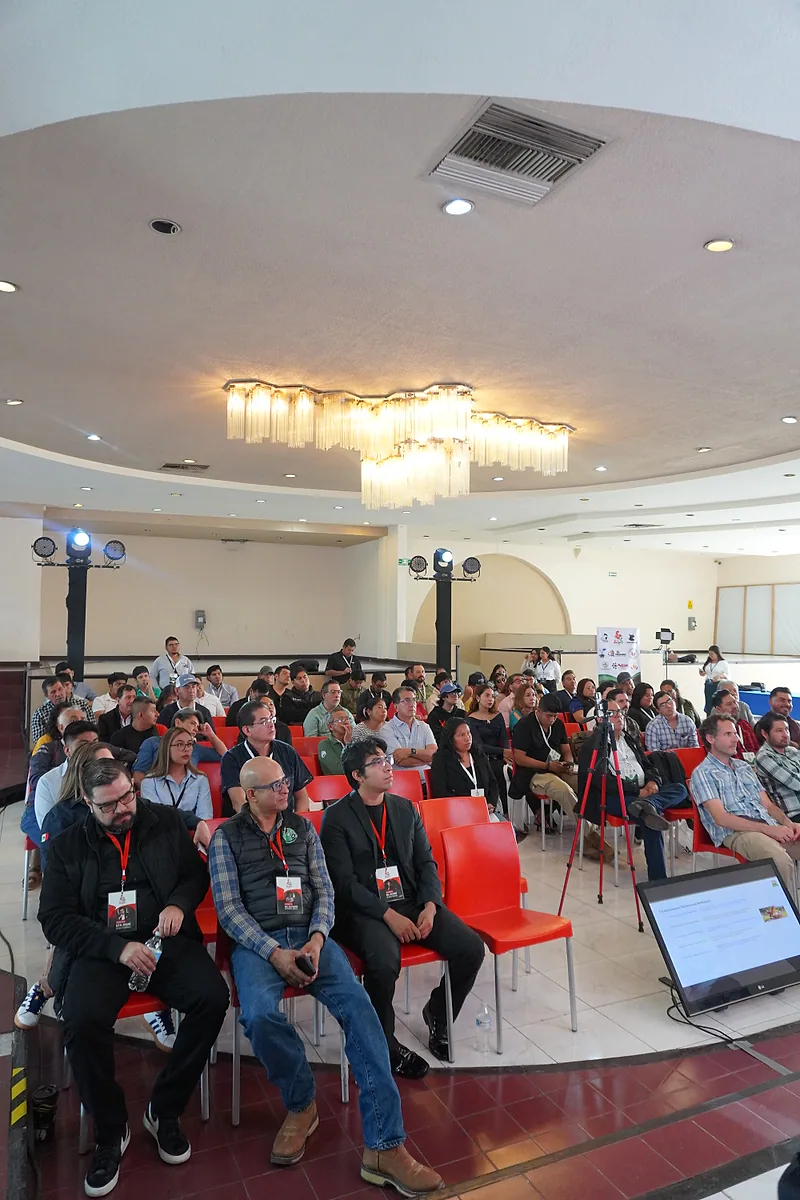 Vista vertical de la audiencia siguiendo una conferencia.